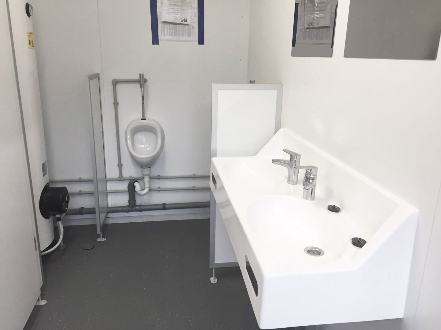 Sanitaire avec double vasque, urinoir dans un local social modulaire